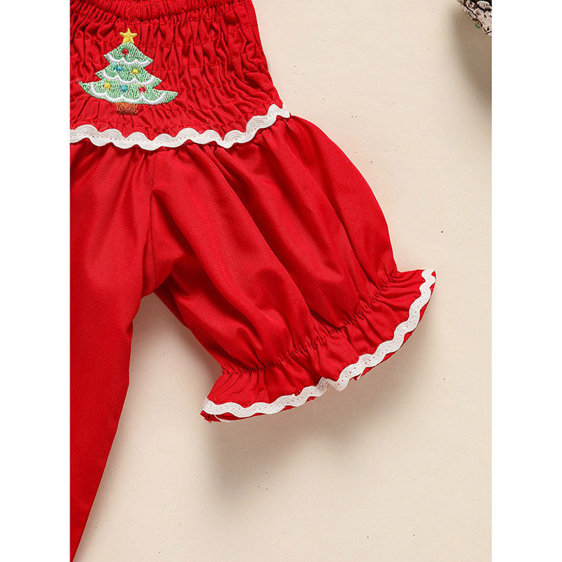 Red baby bloomers with a Christmas tree design on a beige background