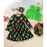 Black dress with Christmas grinch pattern, green vest, and festive decorations on a light background