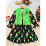 Children's outfit with black dress featuring Christmas-themed print, green fur vest, and red heart on a beige background.