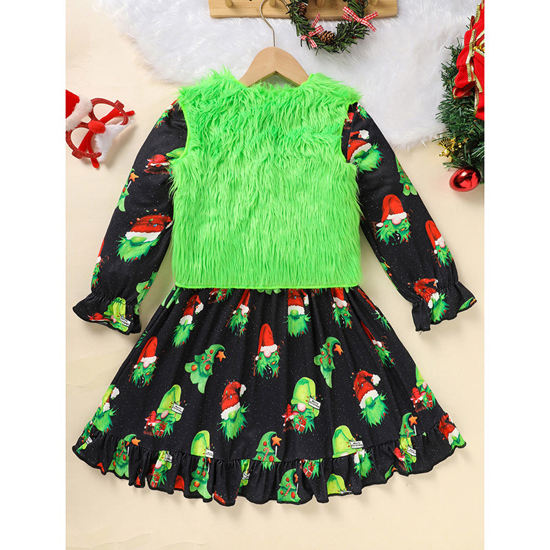 Children's dress with green fluffy top and black skirt with Christmas-themed pattern on a beige background.