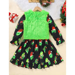 Children's dress with green fluffy top and black skirt with Christmas-themed pattern on a beige background.
