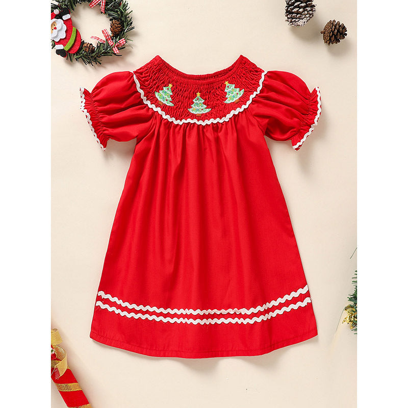 Red dress with white trim and Christmas tree embroidery on a beige background